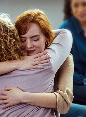 Two women hug. 